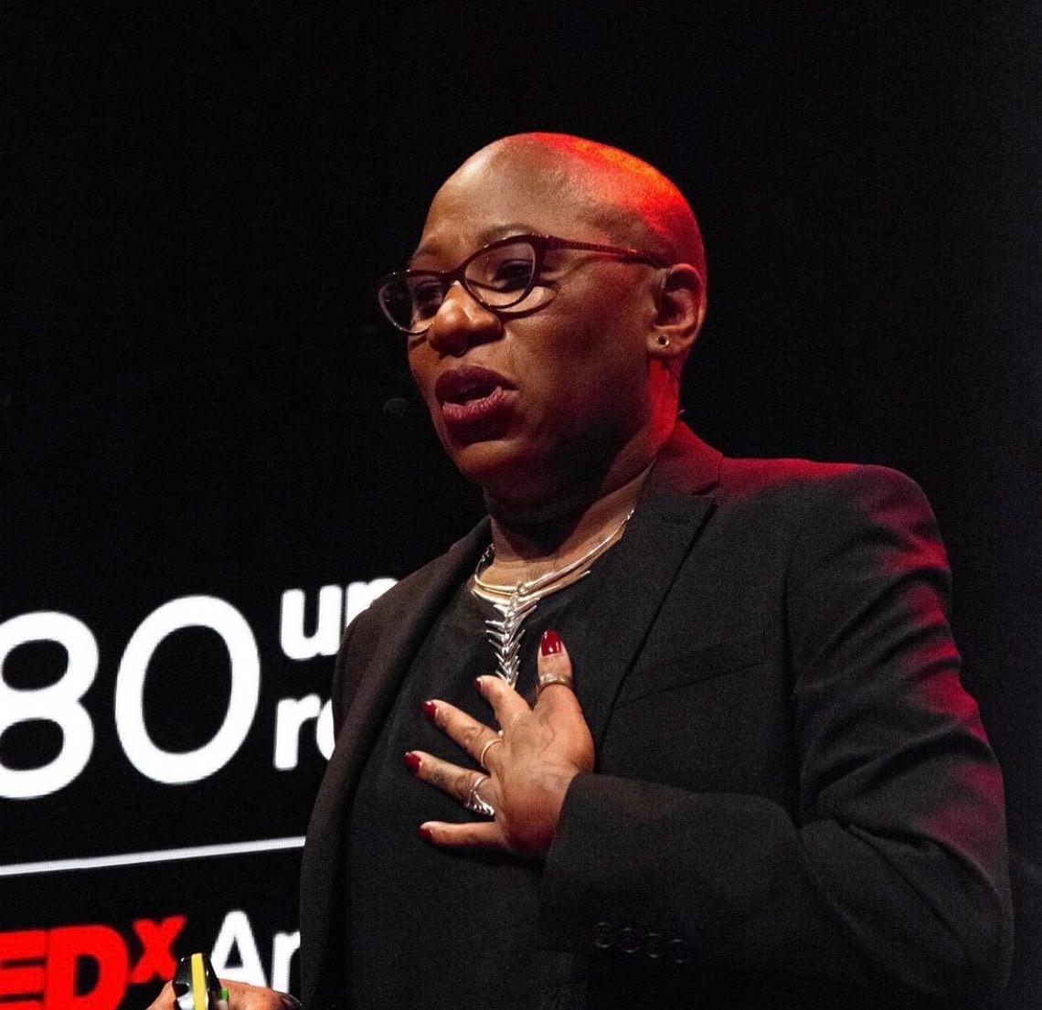 Ada Parris speaking at TEDxAmsterdam, hand on heart